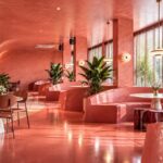 Interior cafe aesthetic dengan booth pink dan cahaya jendela, ilustrasi suasana brunch