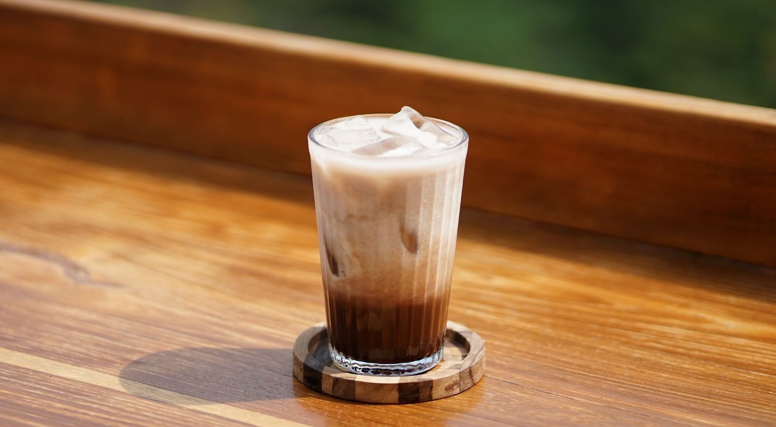 Segelas es kopi susu di pagar kayu Kedai Bukit Rhema